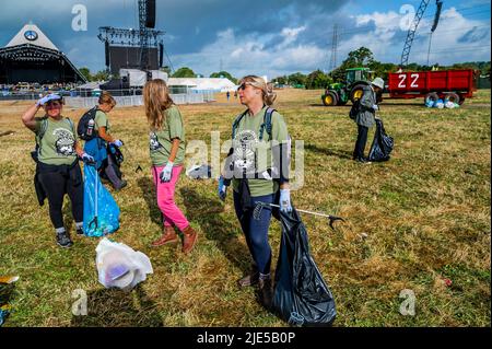 Pilton, Royaume-Uni. 25th juin 2022. Des milliers de bénévoles (beaucoup de collecte d'argent pour les organismes de bienfaisance) nettoient les déchets laissés par les festivaliers la nuit précédente (dans ce cas à l'étape Pyramid). Le travail est nécessaire en dépit de la devise du festival pour «ne laisser aucune trace» - le Glastonbury Festival 50th 2022, digne ferme. Glastonbury, Credit: Guy Bell/Alamy Live News Banque D'Images