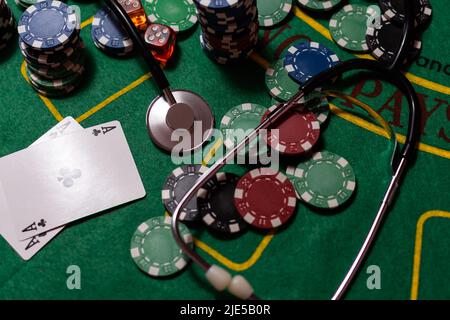 jetons de poker, argent, stéthoscope sur table de blackjack. Banque D'Images