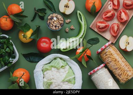 Plat avec légumes frais locaux et fruits sur fond vert. Sans plastique, concept écologique. Idée de vie durable, consommation consciente Banque D'Images