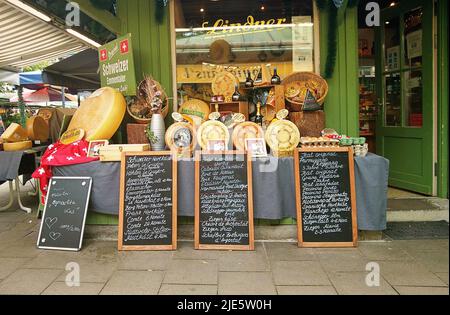 Le magasin de spécialités au fromage du Deli au Viktualienmarkt, point gastronomique à Munich - Allemagne, avec les offres quotidiennes sur les tableaux Banque D'Images