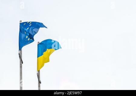 Drapeau de l'Ukraine et de l'Union européenne agitant ensemble dans le ciel blanc, espace de copie Banque D'Images