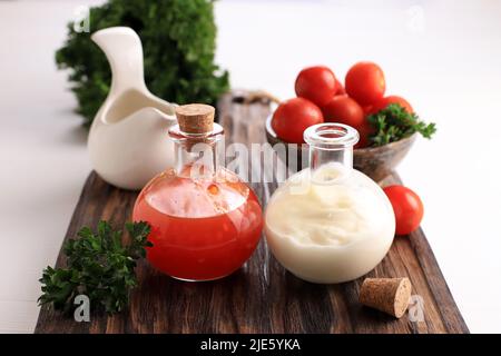 Sauce épicée et mayonnaise sur une petite bouteille au-dessus de la table en bois blanc Banque D'Images