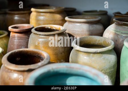 Beaucoup de cruches et vases en argile uniques et colorés faits à la main de formes diverses sur l'étagère dans le marché local Banque D'Images