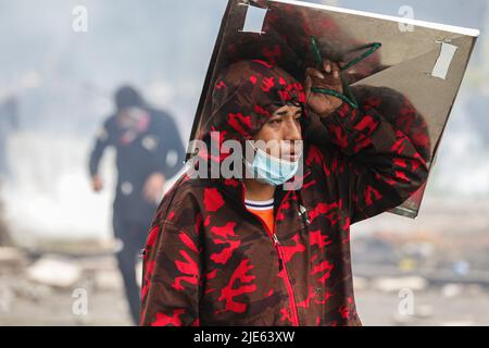 Quito, Équateur. 24th juin 2022. Un manifestant couvre sa tête avec un bouclier fait à la main pendant la démonstration. Le douzième jour de manifestations en Équateur, au parc Arbolito, des autochtones et des forces de police se sont affrontés lors d'une manifestation contre le gouvernement de Guillermo Lasso. Crédit : SOPA Images Limited/Alamy Live News Banque D'Images