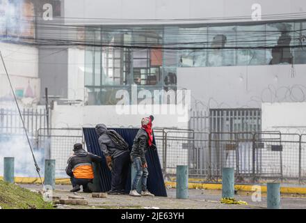 Quito, Équateur. 24th juin 2022. Les manifestants se cachent derrière un bouclier fait à la main lors de la confrontation avec la police nationale équatorienne. Le douzième jour de manifestations en Équateur, au parc Arbolito, des autochtones et des forces de police se sont affrontés lors d'une manifestation contre le gouvernement de Guillermo Lasso. Crédit : SOPA Images Limited/Alamy Live News Banque D'Images