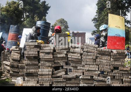 Quito, Équateur. 24th juin 2022. Les manifestants se cachent derrière des blocs et des boucliers faits à la main lors de la confrontation avec la police nationale équatorienne. Le douzième jour de manifestations en Équateur, au parc Arbolito, des autochtones et des forces de police se sont affrontés lors d'une manifestation contre le gouvernement de Guillermo Lasso. Crédit : SOPA Images Limited/Alamy Live News Banque D'Images