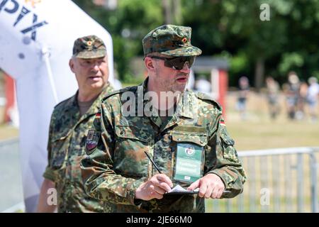 25 juin 2022, Rhénanie-du-Nord-Westphalie, Warendorf : un soldat note les résultats aux finales du championnat allemand de réserviste. Environ 50 autres organisations et exposants se sont présentés sur le terrain de Lohwall. Les finales du championnat allemand de réserviste y sont également organisées. Photo: David Inderlied/dpa Banque D'Images