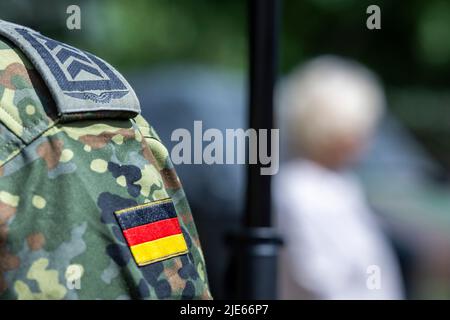 25 juin 2022, Rhénanie-du-Nord-Westphalie, Warendorf : un soldat observe la conférence de presse avec le ministre de la Défense Lambrecht (SPD) lors de la Bundeswehr Day. Environ 50 autres organisations et exposants se sont présentés sur la région de Lohwall. De plus, les finales du championnat allemand de réserviste y auront lieu. Photo: David Inderlied/dpa Banque D'Images