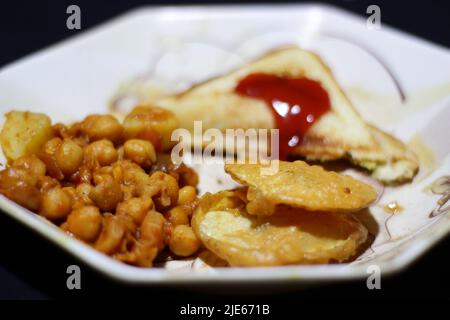 Gros plan de petits pois chiches et de pommes de terre dans l'assiette Banque D'Images