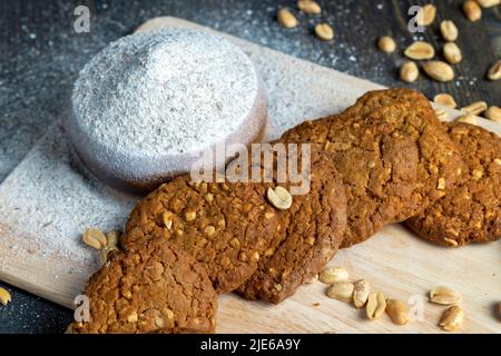 biscuits aux flocons d'avoine avec arachides sur une table en bois noir, biscuits faits maison aux flocons d'avoine avec noix d'arachide Banque D'Images