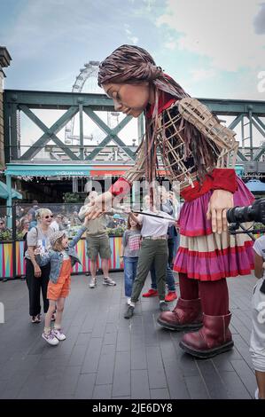 Londres, Royaume-Uni. 25th juin 2022. Little Amal revient en ville pour une brève présentation et représentation pour les enfants et les familles au centre Southbank. Amal, qui signifie espoir en arabe, est en voyage de Turquie depuis juillet et a été créé par Handspring, la société qui a fait les marionnettes équines de War Horse. La marionnette de 3,5meter d’une jeune fille syrienne de neuf ans représente les millions d’enfants contraints de quitter leur foyer dans des situations désespérées. Credit: Guy Corbishley/Alamy Live News Banque D'Images