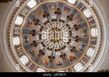 un beau lustre sur un plafond rond peint dans une église catholique Banque D'Images