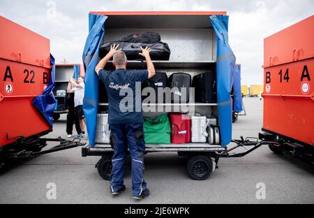 Norddeich, Allemagne. 25th juin 2022. Un employé d'AG Reederei Norden-Frisia porte les bagages des touristes se rendant sur l'île de Juist dans une voiturette à bagages. La Rhénanie-du-Nord-Westphalie est le premier État allemand à commencer ses vacances d'été. Credit: Hauke-Christian Dittrich/dpa/Alay Live News Banque D'Images