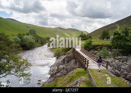 Une passerelle à Glen Tilt, au-dessus de l'inclinaison de la rivière, près de Blair Atholl, dans le Perthshire, en Écosse. Banque D'Images