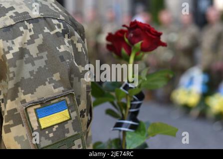 Funérailles d'hommes ukrainiens tués lors de l'invasion de l'Ukraine par la Russie. Le soldat tient des fleurs Banque D'Images