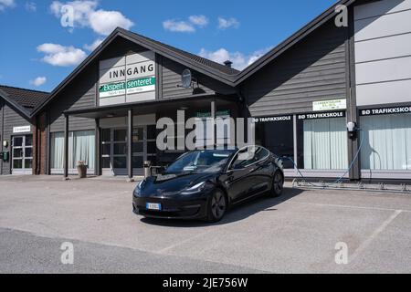 Bo, Norvège - 26 mai 2022 : un cliché statique d'une charge de moteur double Tesla noir solide modèle 3 à la station de charge de l'école de conduite Salto ABL AC en a. Banque D'Images