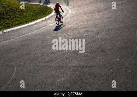 Silhouette d'un entraînement de motard sur la piste de course de vélo dans un parc. Photo de fond de style de vie sain ou d'entraînement ou de sport. Banque D'Images