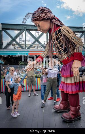 Londres, Royaume-Uni. 25th juin 2022. Little Amal revient en ville pour rencontrer et accueillir les enfants et les familles au centre Southbank. Amal, dont le nom signifie espoir en arabe, est en voyage de Turquie depuis juillet et a été créé par Handspring, la société qui a fait les marionnettes équines dans War Horse. La marionnette de 3,5meter d’une jeune fille syrienne de neuf ans représente les millions d’enfants contraints de quitter leur foyer dans des situations désespérées. Credit: Guy Corbishley/Alamy Live News Banque D'Images