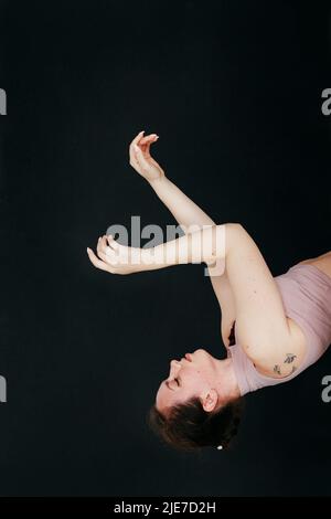 Gros plan portrait en studio d'une jeune fille brune effectue des mouvements fluides avec ses mains. Concept pour les procédures cosmétiques et la manucure. Banque D'Images