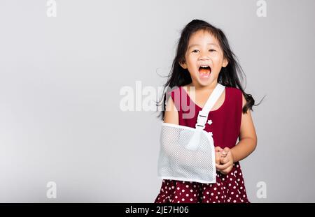 Bras cassé. Petit mignon enfant fille de 3-4 ans os de main cassé d'accident avec attelle de bras dans le studio de tir isolé sur fond blanc, enfant asiatique Banque D'Images