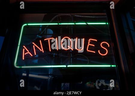 Panneau d'antiquités rouge et vert illuminant d'une fenêtre sombre Banque D'Images