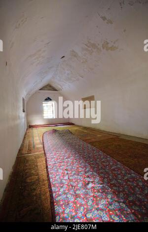 Un petit espace privé, intime et blanc voûté à la mosquée Norbutabiy pour prier. À Kokand, dans la vallée de Fergana, en Ouzbékistan. Banque D'Images