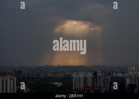 La lumière du soleil traverse les nuages de tempête et tombe sur Gurugram,Haryana,l'horizon de l'Inde au coucher du soleil.Delhi NCR posh immobilier, quartier des affaires. Banque D'Images