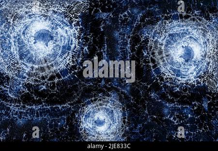 Trous de balle dans la vitre de fermeture sur fond noir Banque D'Images