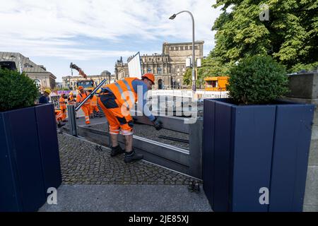 Dresde, Allemagne. 26th juin 2022. Un employé du Regiebetrieb Zentrale Technische Dienstleistungen (RB ZTDL) de la ville met un élément de protection contre les inondations dans l'appareil. Lors de l'installation d'essai du système de protection mobile contre les inondations dans le centre-ville de Dresde, des travaux d'entretien sont effectués sur le système, les éléments sont nettoyés et leur fonctionnalité testée. Credit: Daniel Schäfer/dpa/Alay Live News Banque D'Images