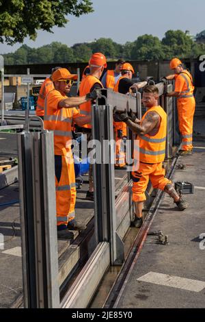 Dresde, Allemagne. 26th juin 2022. Les employés du Regiebetrieb Zentrale Technische Dienstleistungen (RB ZTDL) de la ville récupèrent un élément de protection contre les inondations dans une pile. Lors de l'installation d'essai du système de protection mobile contre les inondations dans le centre-ville de Dresde, des travaux d'entretien sont effectués sur le système, les éléments sont nettoyés et leur fonctionnalité testée. Credit: Daniel Schäfer/dpa/Alay Live News Banque D'Images