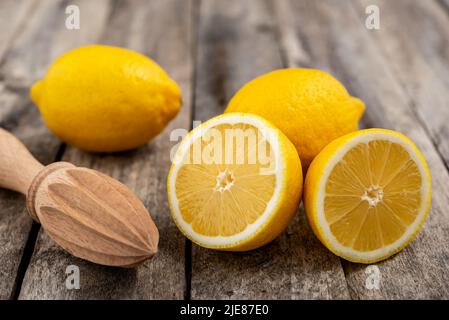 Citrons frais et centrifugeuse en bois sur table rustique. Mise au point sélective. Banque D'Images