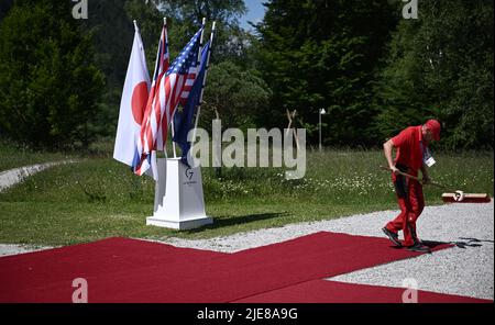 Un ouvrier nettoie le tapis rouge sur un lieu de bienvenue avant le sommet des dirigeants de G7 au château de Schloss Elmau, à Elmau, Bavière, Allemagne, 26 juin, 2022. Brendan Smitalowski/Pool via REUTERS