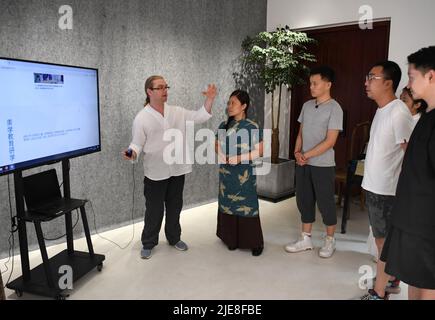 (220626) -- ZHENGZHOU, 26 juin 2022 (Xinhua) -- David Mills (1st L) communique avec les membres du personnel d'un site Web à Zhengzhou, dans la province du Henan, au centre de la Chine, à 22 juin 2022. David Mills est originaire d'Écosse, au Royaume-Uni. Il est venu en Chine en 2006 et, jusqu'à présent, il travaille en Chine depuis 16 ans. Travaillant à l'Université de technologie de Henan dans la province de Henan en Chine centrale, David a rencontré son collègue Shang Na, un amateur de thé. Ils sont devenus de bons amis, sont tombés amoureux, puis se sont mariés. Fasciné par la culture chinoise profonde du thé, David a appris et compris la cérémonie du thé, le makin de thé Banque D'Images