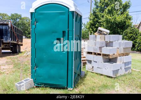 Les toilettes portatives sur le chantier sont utilisées par les travailleurs Banque D'Images