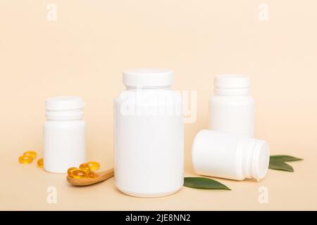 Les capsules Omega-3 se trouvent dans une bouteille blanche sur une table avec un fond de feuilles vertes. Comprimés d'huile de poisson. Additifs biologiquement actifs. omega 6, omega 9, vitam Banque D'Images