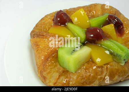 Fermé de la pâtisserie danoise avec des fruits isolés sur fond blanc Banque D'Images