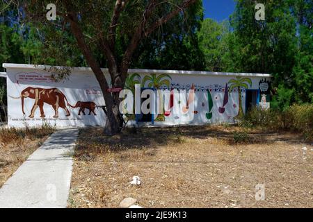 bloc de toilettes et de douche aux couleurs vives, Eristos Beach, Tilos, îles Dodécanèse, Egée du Sud, Grèce. Banque D'Images