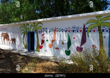 bloc de toilettes et de douche aux couleurs vives, Eristos Beach, Tilos, îles Dodécanèse, Egée du Sud, Grèce. Banque D'Images