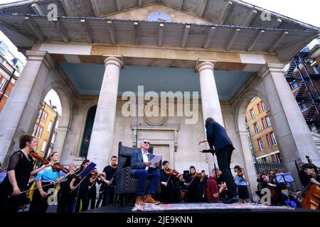 Sir Michael Palin est le narrateur d'une représentation de Peter et du Loup, par le compositeur ukrainien Sergey Prokofiev, avec le Playing for Peace Orchestra - qui présente le chef d'orchestre anglo-russe Petr Limonov, violoniste ukrainien de 11 ans Corey Sheldunov, Et le petit-fils du compositeur Gabriel Prokofiev sur la Corne de France - en face de l'église St Paul, Covent Garden, centre de Londres. Les musiciens du Playing for Peace Orchestra sont issus des meilleurs orchestres de Londres et la représentation collecte des fonds pour l'appel humanitaire d'Ukraine du Comité d'urgence des catastrophes (DEC). Date de la photo: Dimanche lu Banque D'Images