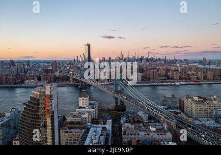 Vue panoramique aérienne de la métropole au crépuscule. Pont de Manhattan et rangée de gratte-ciel au loin. Manhattan, New York, États-Unis Banque D'Images
