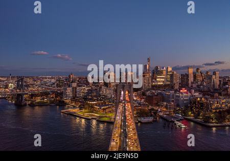 Heure de pointe en soirée sur le pont de Brooklyn, le front de mer et les bâtiments du quartier urbain après le coucher du soleil. Brooklyn, New York, États-Unis Banque D'Images