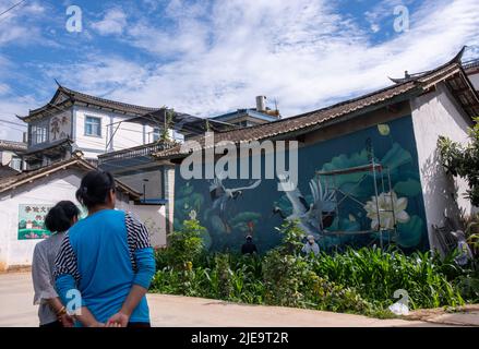 (220626) -- LIJIANG, 26 juin 2022 (Xinhua) -- les villageois voient la peinture murale de Liu Zhicheng dans le village de Cuihu, canton de Sanchuan, comté de Yongsheng, ville de Lijiang, province du Yunnan, au sud-ouest de la Chine, 24 juin 2022. Un peintre mural à but non lucratif « post-95s », originaire du comté de Yongsheng à Lijiang, a gagné en popularité auprès des villageois de sa ville natale et des nétizens sur les plates-formes de médias sociaux. L'artiste mural Liu Zhicheng a peint plus de 20 peintures murales de différents thèmes dans de nombreux villages de sa ville natale. Ses œuvres d'art ont ajouté de la couleur aux villages et attiré de nombreux touristes Banque D'Images