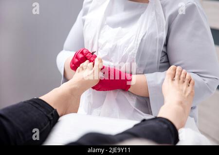 Gros plan sur un podiatre mains traitant les pieds pendant la procédure Banque D'Images