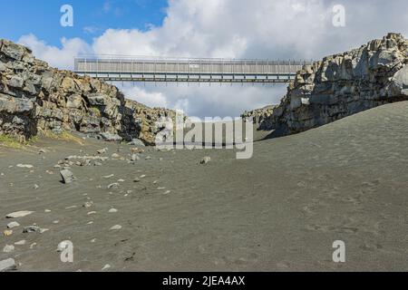 Sable de lave noir avec pont sur l'Islande de la péninsule de Reykjanes. Fissures géographiques des plaques nord-américaines et eurasiennes. Murs en pierre de lave en su Banque D'Images