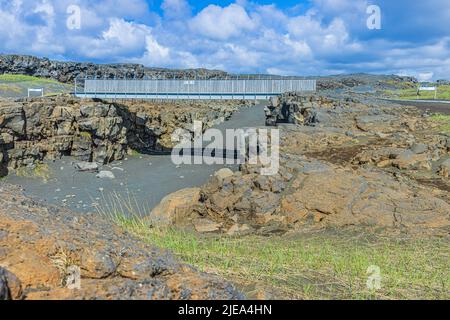 Paysage naturel sur l'Islande de la péninsule de Reykjanes. Pont métallique au milieu de pierres de lave au-dessus des fissures nord-américaines et eurasiennes. Brun Banque D'Images