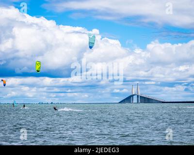 Kiteboarders ou kitesurfers dans la baie de Tampa avec le pont Sunshine Skyway en arrière-plan à Saint-Pétersbourg, Floride, États-Unis Banque D'Images