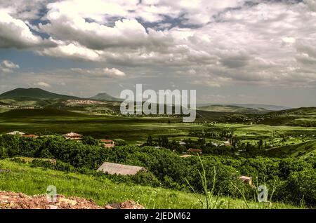 Des nuages qui se profilent dans le ciel bleu ensoleillé au-dessus des villages des hauts plateaux de Tekhenik, Karashamb, Lusakert, au pied des monts Geghama à Arme Banque D'Images