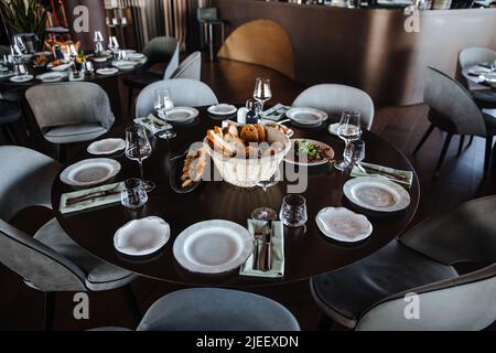 Événement magnifiquement organisé - table ronde banquet prête pour les invités, table ronde décorée avec assiette vide, verres, fourchettes, serviette. Table de dîner élégante Banque D'Images