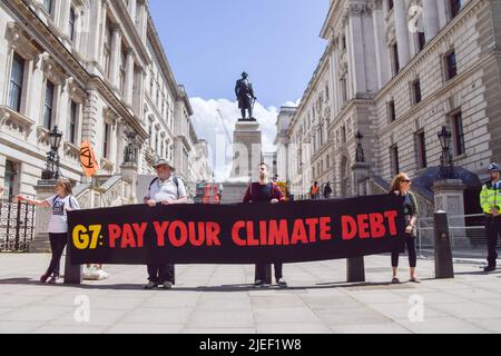 Londres, Angleterre, Royaume-Uni. 26th juin 2022. Les activistes de la rébellion de l'extinction tiennent une bannière "payez votre dette climatique" à côté de la statue de Robert Clive à Westminster. L'action a fait partie de la journée de protestation et de mars exigeant que le G7 annule la dette des pays du Sud mondial, ce qui oblige les nations à extraire des combustibles fossiles pour rembourser les dettes. (Image de crédit : © Vuk Valcic/ZUMA Press Wire) Banque D'Images