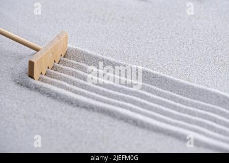 motif dans le sable fait avec un mini outil de jardin zen, un râteau Banque D'Images